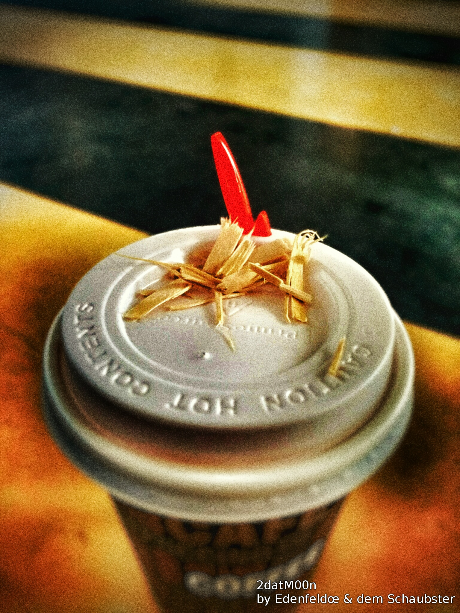 Artistic image of a paper coffee cup with what looks like a red rocket taking of from it.