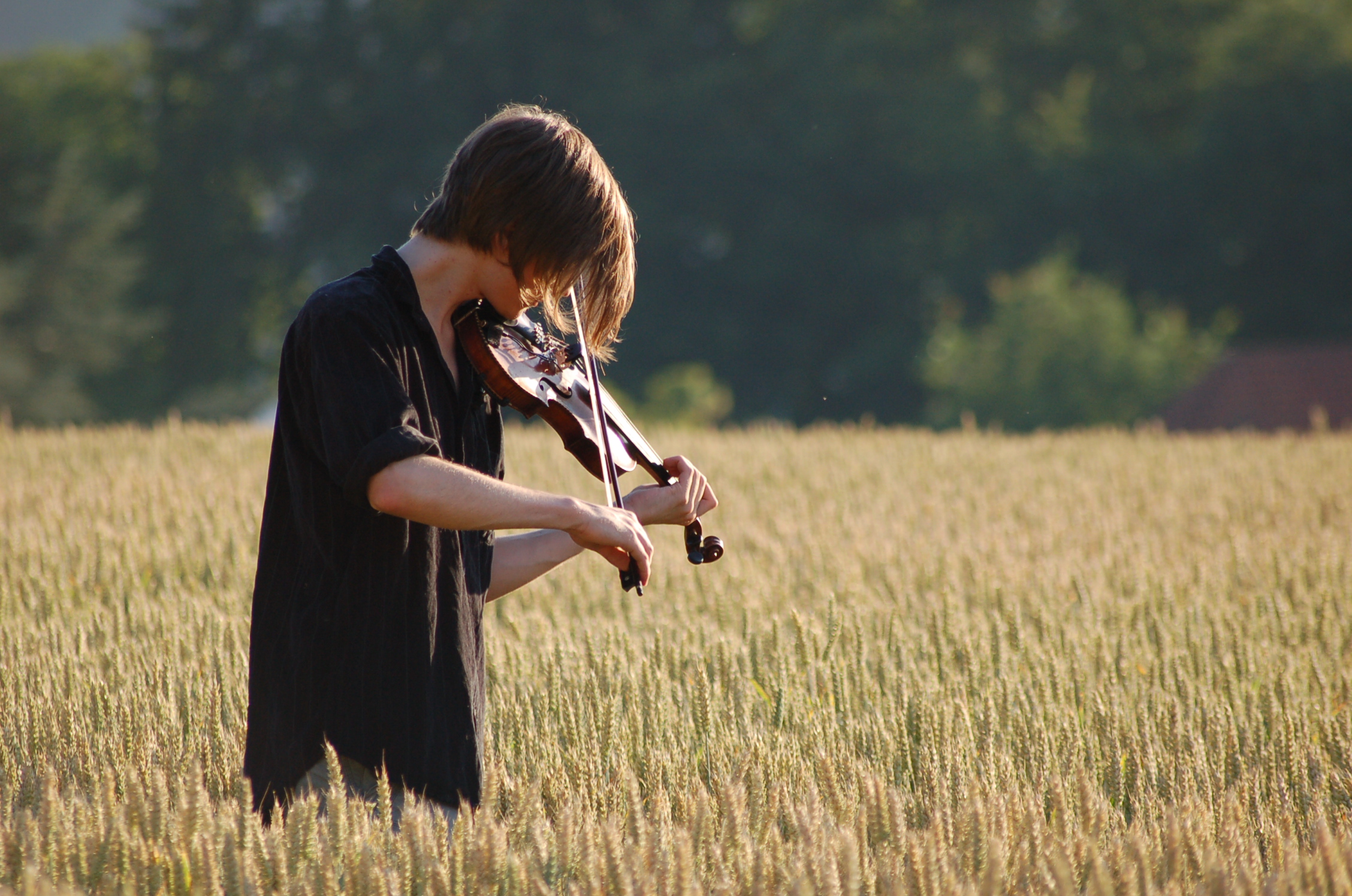 Me standing in a grain field, playing the violin.